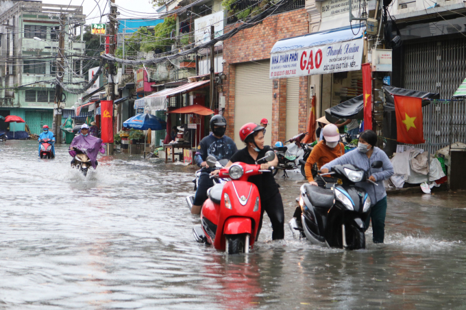 TP.HCM: Mưa trắng trời, người dân TP.HCM phải lội nước dắt xe vì đường phố ngập nặng