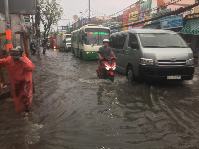 TP.HCM: Mưa trắng trời, người dân TP.HCM phải lội nước dắt xe vì đường phố ngập nặng